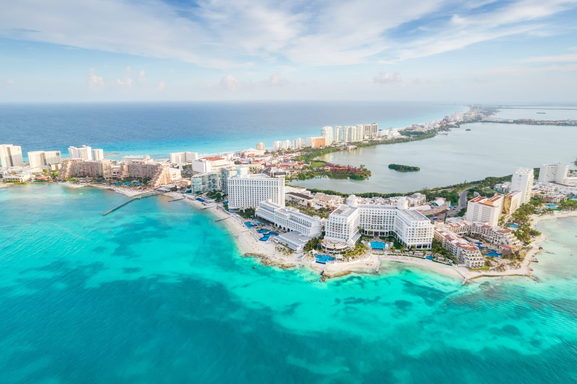 Vista aérea de la zona hotelera de Cancún con hoteles frente al mar turquesa